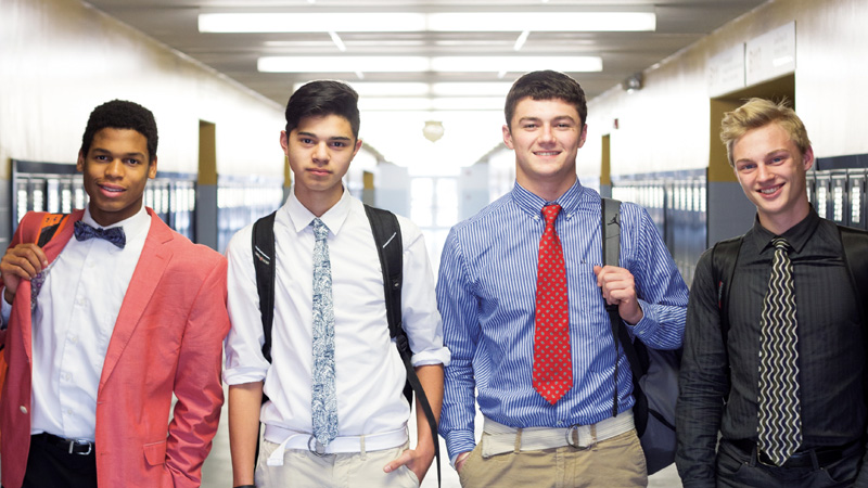 four boys posing for camera inside school